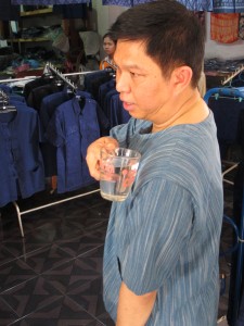 นายวรวัจน์ เอื้อภิญญกุล รมว.วท. ทดสอบการเทน้ำลงบนเสื้อเพื่อพิสูจน์คุณสมบัติสะท้อนน้ำ